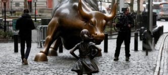 A+statue+of+a+young+girl+staring+down+the+Wall+Street+bull+just+appeared+today+in+Manhattan