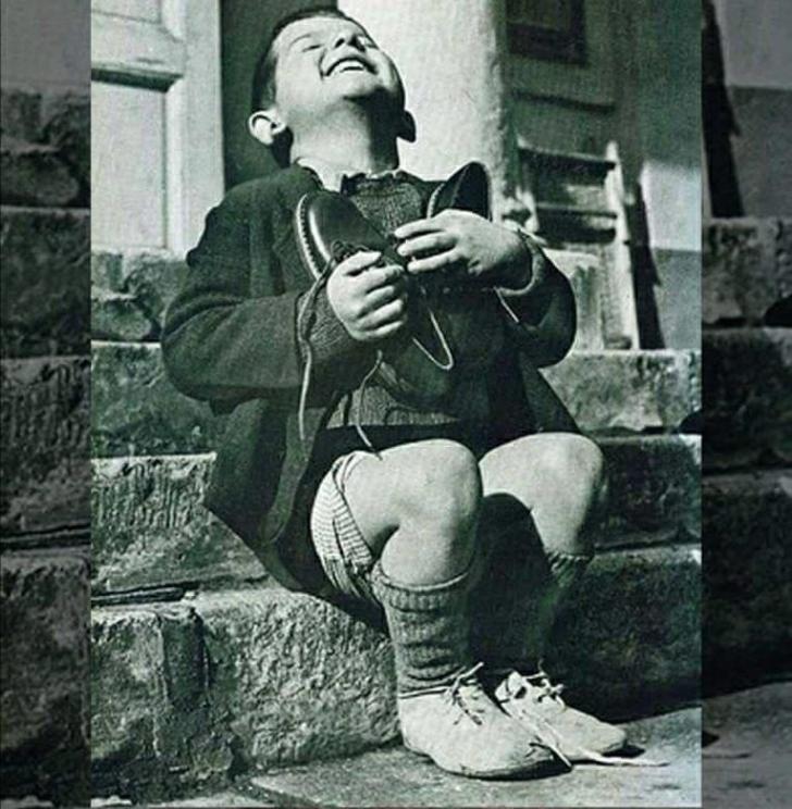 Orphaned+boy+showing+immense+joy+on+receiving+new+pair+shoes+as+a+birthday+gift+1946