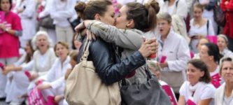Lesbian+couple+kissing+in+front+of+an+anti-gay+parade+in+France.