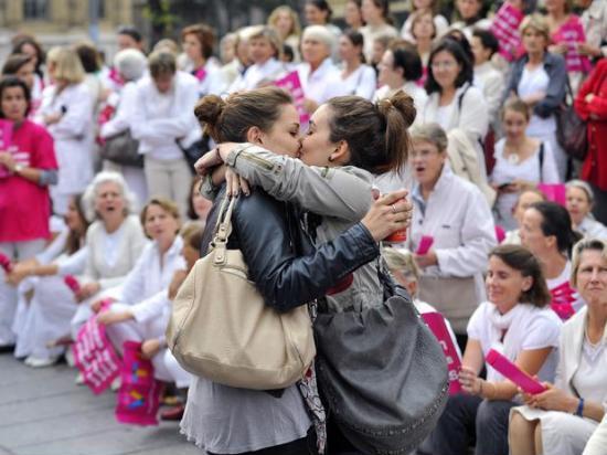 Lesbian+couple+kissing+in+front+of+an+anti-gay+parade+in+France.