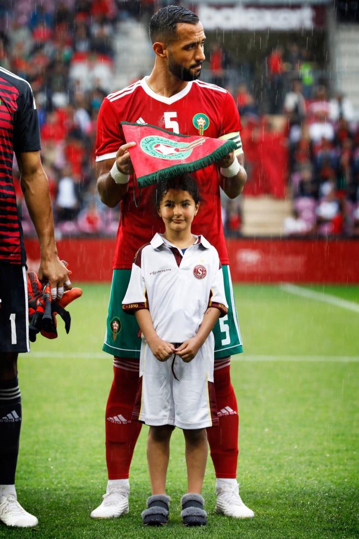 Moroccan+soccer+team+captain+Benatia+covering+a+little+girl%26%238217%3Bs+head+from+the+rain