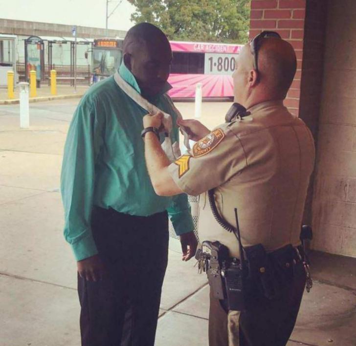 Police+officer+helping+citizen+put+on+a+tie+before+a+job+interview.