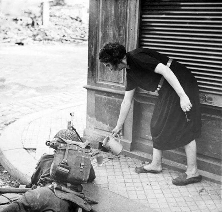 French+woman+pours+a+hot+cup+of+tea+for+a+British+soldier+fighting+in+Normandy%2C+1944.