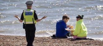 Police+Officer+confronting+two+people+having+lunch+on+a+Beach+during+Quarantine.