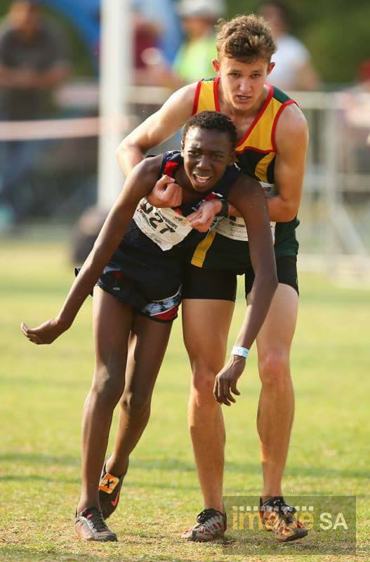 This+kid+helping+an+athlete+from+another+province+finish+his+event