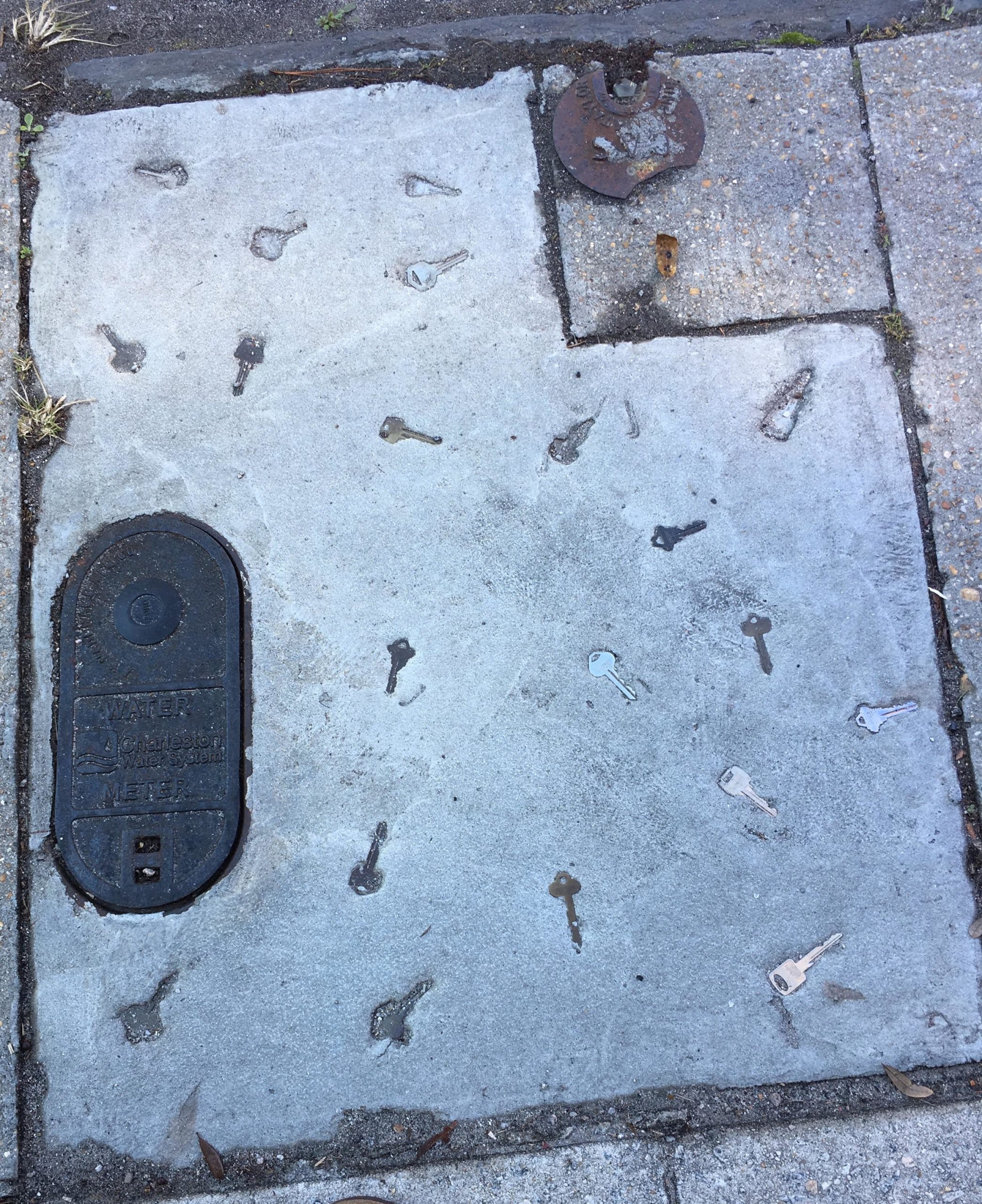 The+sidewalk+in+front+of+a+locksmith+has+keys+in+it.